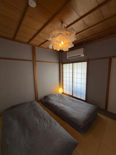 a bedroom with two beds and a chandelier at 玄Gen Private Villa in Takayama