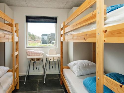 a dorm room with two bunk beds and a window at 14 person holiday home in Glesborg in Glesborg