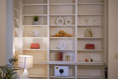 a white book shelf with glasses and vases on it at The Underwood-Hale House in Providence