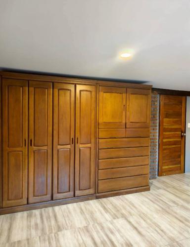 a large closet with wooden cabinets in a room at Termcheewa Homestay in Chiang Rai