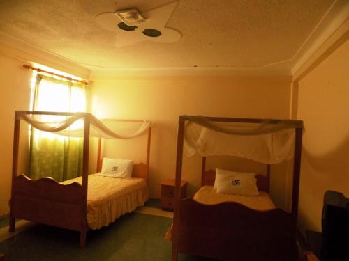 Postel nebo postele na pokoji v ubytování Palm Springs Hotel Masaka