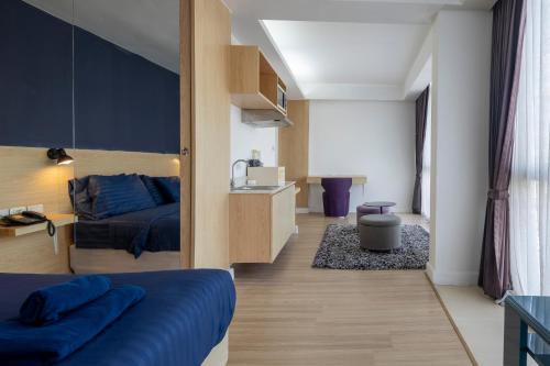 a small room with a bed and a kitchen at GP House Express Sukhumvit 81 in Bangkok