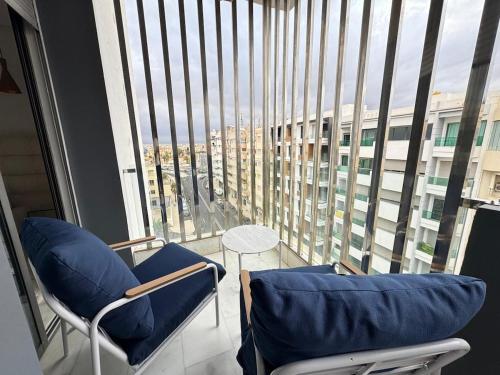 a room with two chairs and a large window at Comfortable 3 bedroom apartment ideally located in Fès
