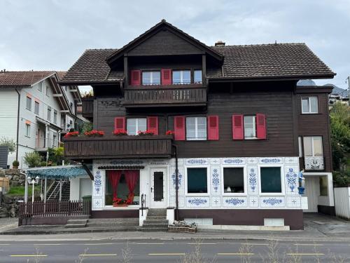 a house with red and white shutters on a street at Studio apartment - Park view in Thun