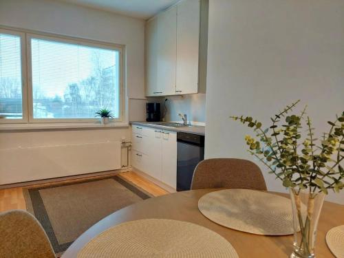 a kitchen with a table with chairs and a dining room at Kodikas parvekkeellinen kaksio omalla parkkipaikalla in Kokkola
