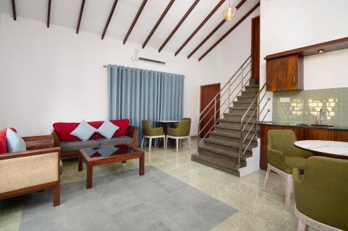 a living room with a couch and chairs and stairs at Gedara Villa in Kalutara