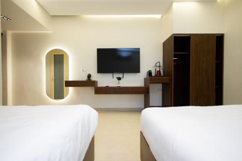 a hotel room with two beds and a flat screen tv at Imperial Luxury Hotel in Cairo