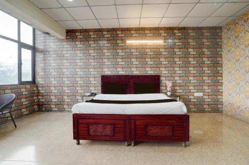 a bedroom with a bed in a brick wall at Collection O Sector 58 Mohali in Mohali