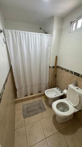 a bathroom with a toilet and a shower curtain at Departamento Boulevares in Concepción del Uruguay