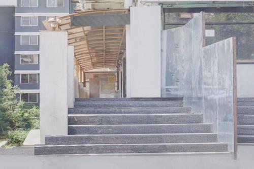 a set of stairs in front of a building at Collection O Ambegaon Road Katraj White Castle in Māngvādi
