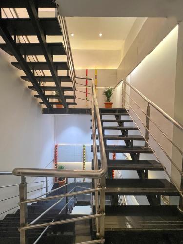 a staircase in a building with a metal railing at Hotel Rexton Inn in Mumbai