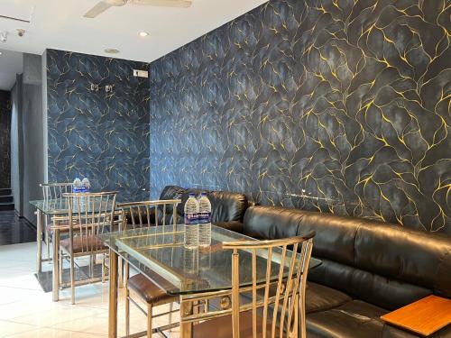 a restaurant with a leather couch and tables and chairs at Hotel Rexton Inn in Mumbai
