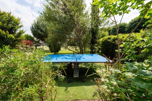 a picnic table in the middle of a garden at Maison Piscine & Tennis - Collection Idylliq in Muids