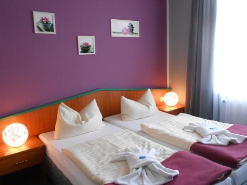 two beds in a room with towels on them at GreenLine Ferienhotel Forelle in Thale