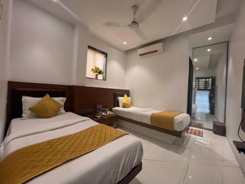 a hotel room with two beds and a window at Hotel Rexton Inn in Mumbai