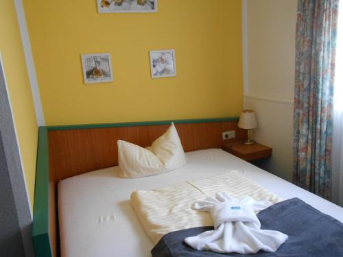 a bedroom with a bed with two stuffed animals on it at GreenLine Ferienhotel Forelle in Thale