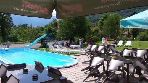 een zwembad met stoelen en een glijbaan bij Bran Belvedere International in Bran