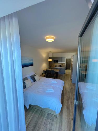 a bedroom with a large bed and a dining room at Lipno Loft - Korzo in Lipno nad Vltavou