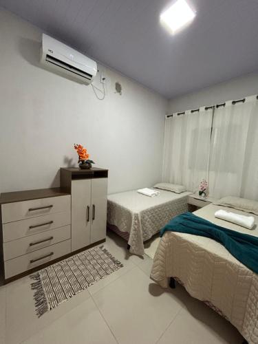 a bedroom with two beds and a air conditioner at casa de veraneio jalapão in São Félix do Tocantins