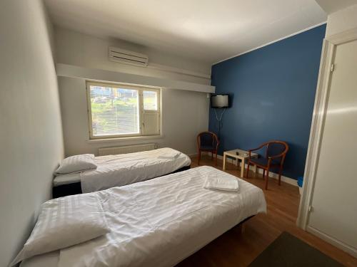 a hotel room with two beds and a window at Hotel Airisto Marina in Pargas