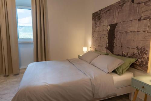 a bedroom with a large bed with a stone wall at Ferentino B&B in Ferentino