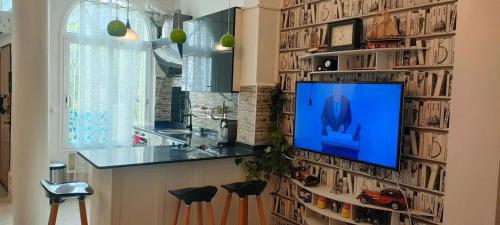a living room with a tv hanging on a wall at Le mistral in Sidi MʼHamed