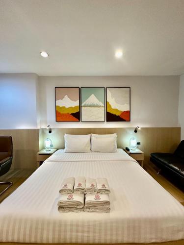 a bedroom with a large bed with three folded towels on it at Sakura Sky Residence in Bangkok
