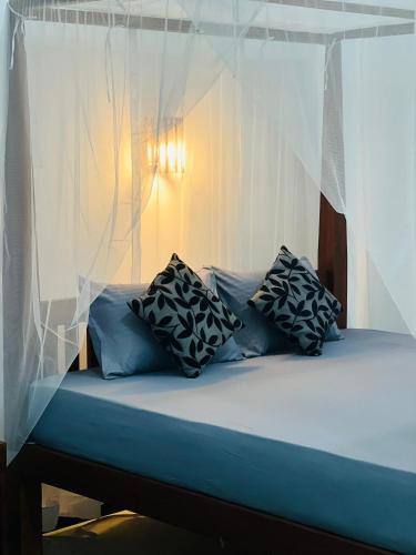 a bed with a canopy with pillows on it at Jungle Restaurant and Villa in Unawatuna