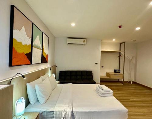 a bedroom with a white bed and a room with at Sakura Sky Residence in Bangkok
