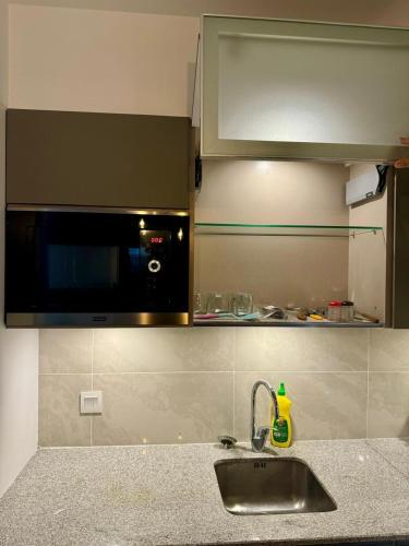 a kitchen with a sink and a microwave at Penta Square Executive Hotel Apartments City View DHA Lahore in Lahore