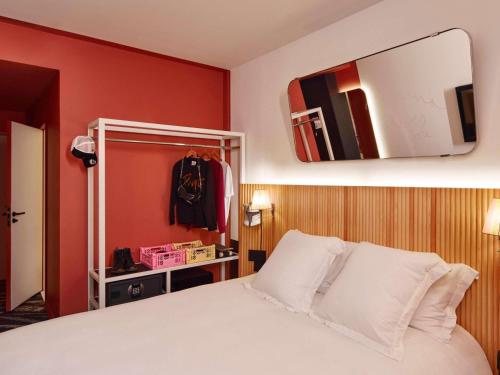 a bedroom with a white bed and a mirror at Mama Shelter Paris La Défense in Puteaux