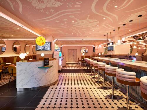 a restaurant with a bar and stools at Mama Shelter Paris La Défense in Puteaux