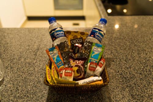 a basket of bottled water and snacks on a counter at Penta Square Executive Hotel Apartments City View DHA Lahore in Lahore