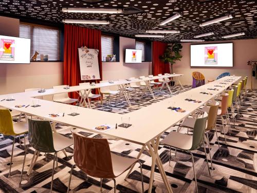 a conference room with long tables and chairs at Mama Shelter Paris La Défense in Puteaux