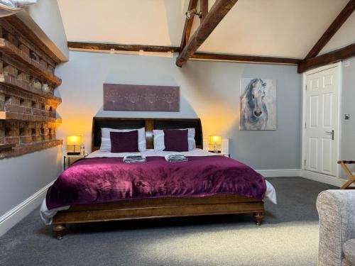 a bedroom with a bed with a purple bedspread at Studio 3B The Carriage House York 6m Village Location in York