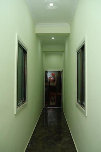 an empty hallway with green walls and two windows at Hotel Avtar Palace in Jāmb