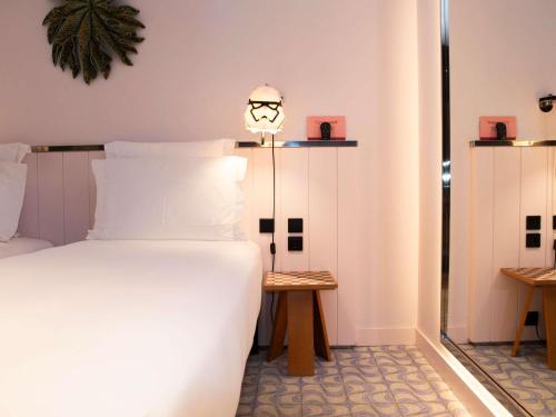 a bedroom with a white bed and a lamp at Mama Shelter Lisboa in Lisbon