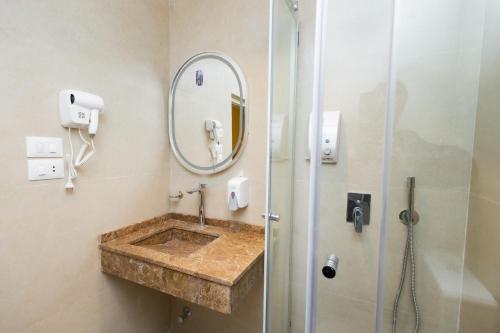 a bathroom with a sink and a shower with a mirror at Imperial Luxury Hotel in Cairo