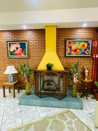 a fireplace in a room with a brick wall at Hotel Garnier in Campos do Jordão