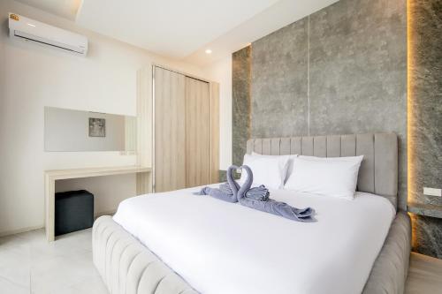 a bedroom with a large white bed and a fireplace at Luxury Pool Villa Samui - Elabel in Amphoe Koh Samui