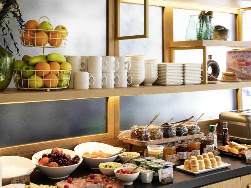 a kitchen counter with plates and bowls of food at ibis Styles Paris Gare De Lyon TGV in Paris