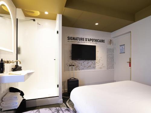 a bedroom with a bed and a flat screen tv at ibis Styles Paris Gare De Lyon TGV in Paris
