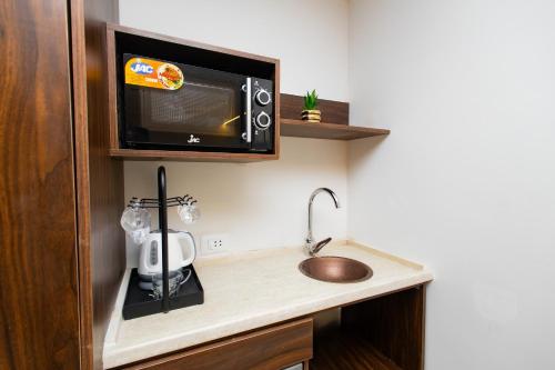 a kitchen with a sink and a microwave at Imperial Luxury Hotel in Cairo