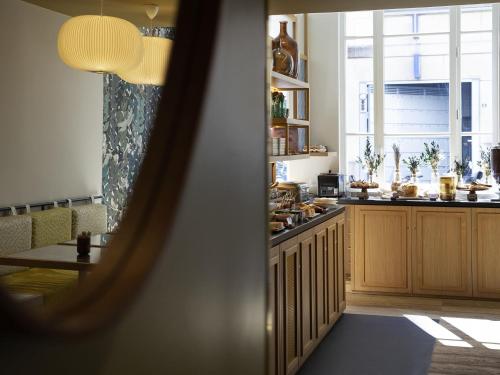a kitchen with wooden cabinets and a table and a window at ibis Styles Paris Gare De Lyon TGV in Paris