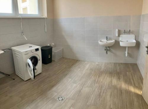 a bathroom with a washing machine and a sink at Malom Munkásszálló in Karcag