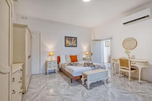 a white bedroom with a bed and a desk at Luxury Villa Sea Views Heart of St Julians in St. Julianʼs