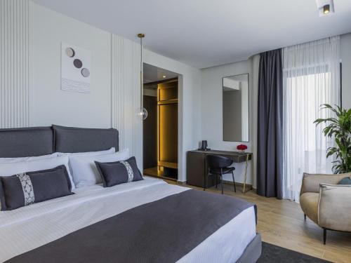 a hotel room with a large bed and a desk at Mövenpick Hotel Lalez Durres in Durrës