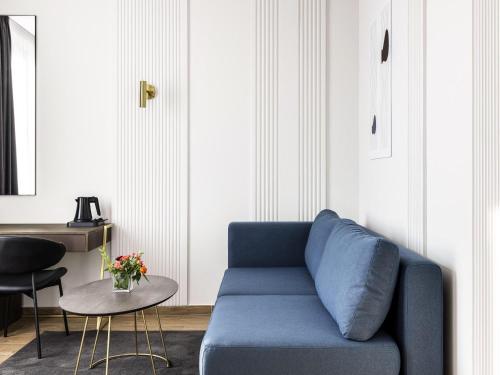 a blue couch in a living room with a table at Mövenpick Hotel Lalez Durres in Durrës