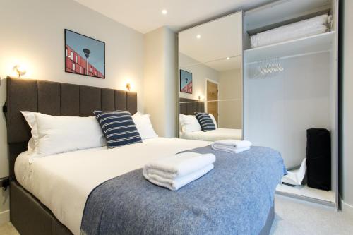 a bedroom with a large bed with towels on it at Madison Hill - Byrne Garden 2 - One bedroom home in London