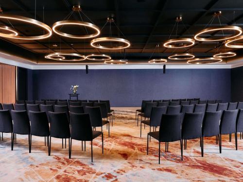 a room with a row of chairs and a stage at Mercure Melbourne Doncaster in Doncaster